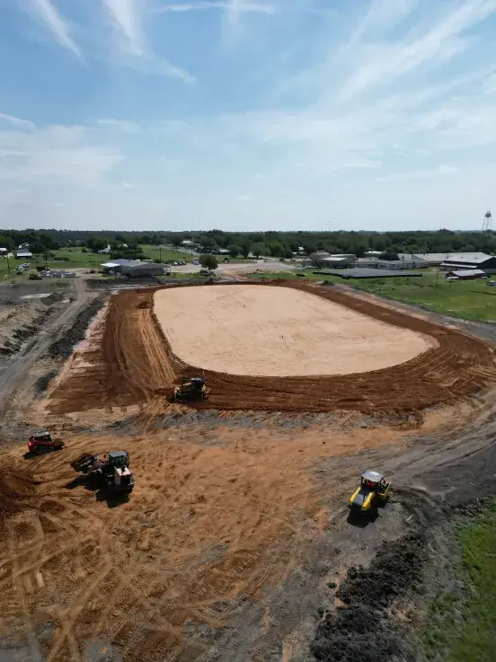 Aerial view of a finished building pad surrounded by graded red dirt