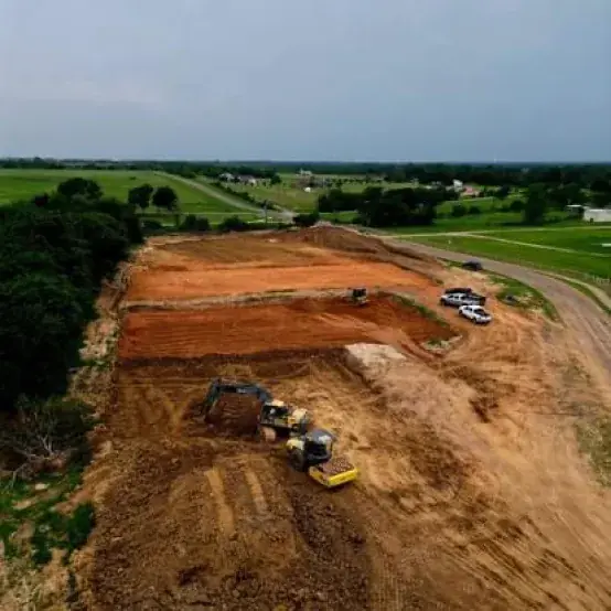 Aerial view of a large pad being cut into a hillside with dozers working