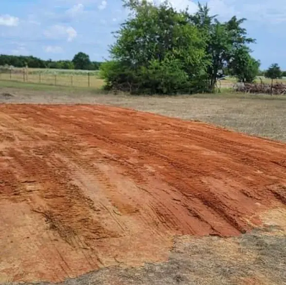 Freshly shaped red dirt pad ready for compaction