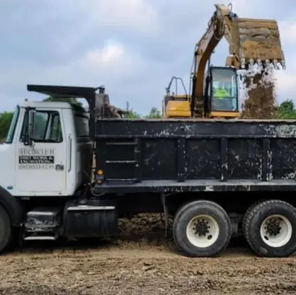 Excavator loading a dump truck with dirt