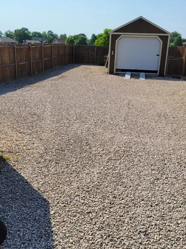 Finished gravel driveway leading to a detached garage