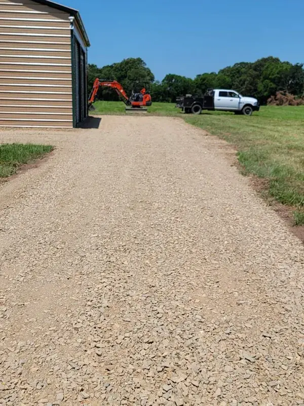 Long gravel driveway running past a house to the road