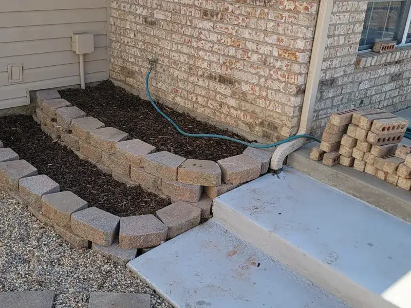 Retaining block planter and concrete steps built at a brick home