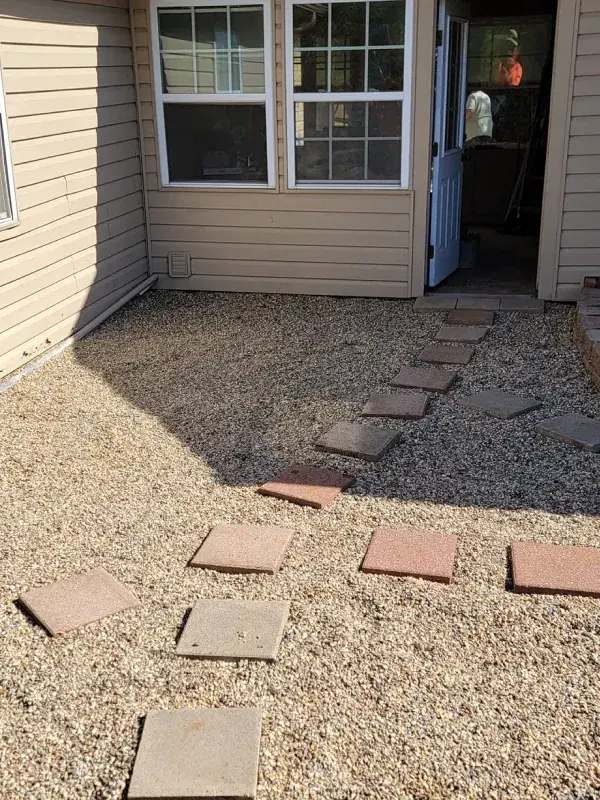 Prepared walkway area outside a home entry with pavers staged