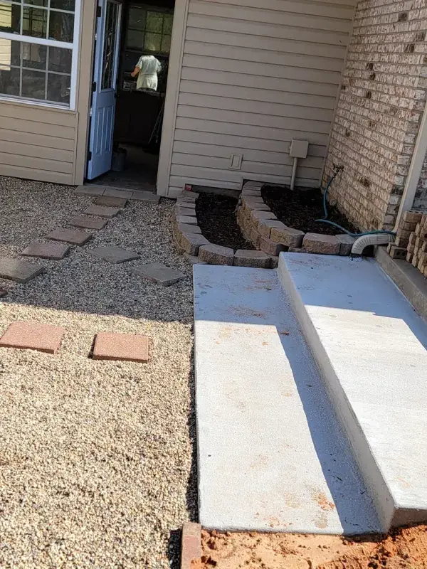 New concrete steps and walkway at the side door of a brick home