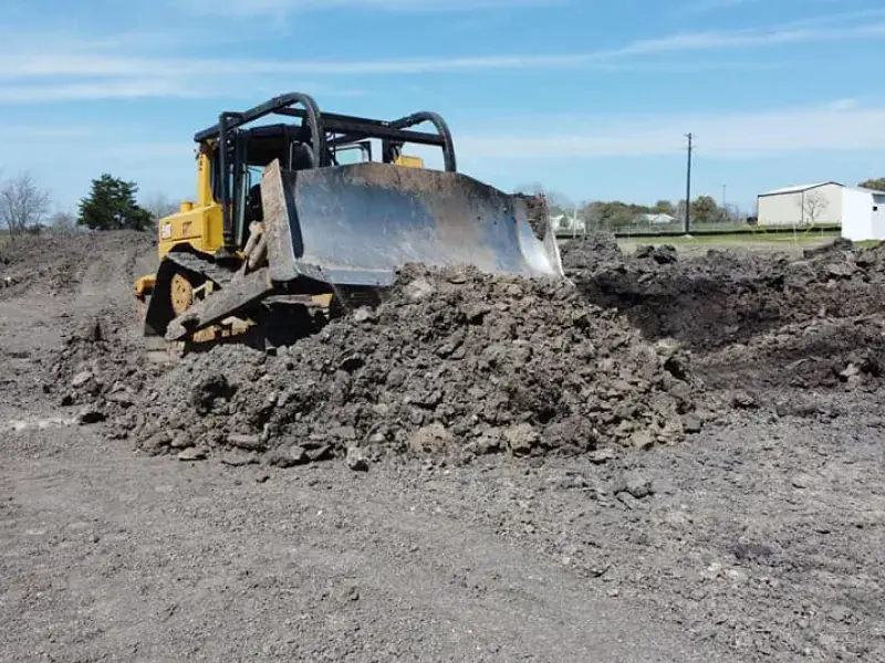 Dozer pushing a pile of dirt and debris